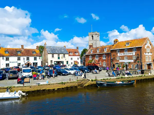 Wareham Quay on the River Frome with historic buildings and the church tower behind
