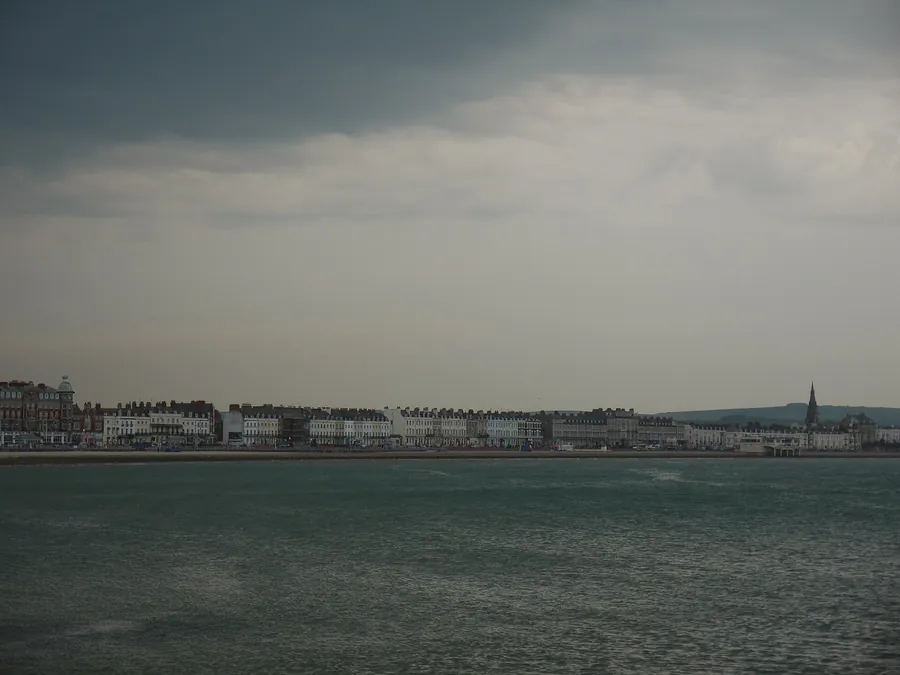 Dark storm clouds over Weymouth Bay and the seafront terraces