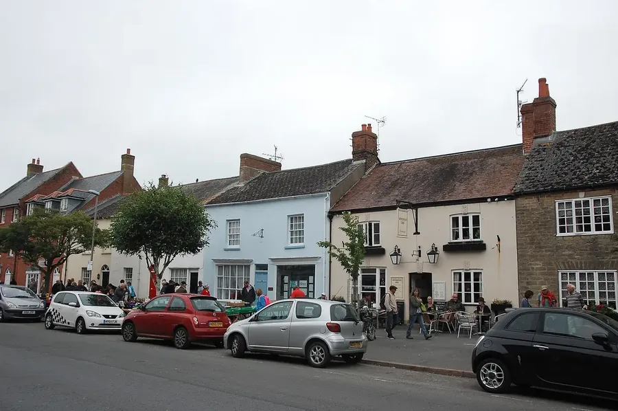 Shops and terraced buildings with tiled roofs on South Street, Bridport