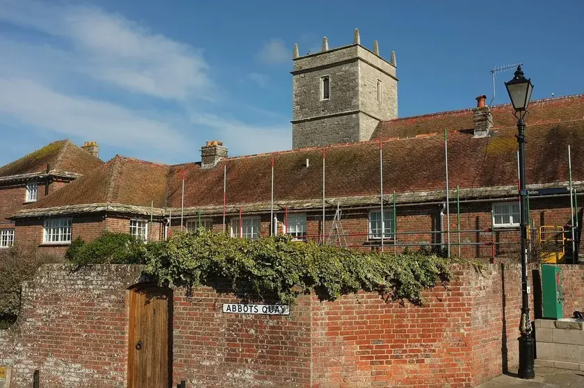 Clay tiled roofs at Abbots Quay with the tower of Holy Trinity church, Wareham